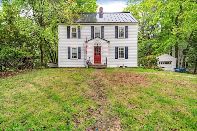 4 University Pl, Orono, ME 04473 - colonial-style house featuring a chimney, metal roof, a standing seam roof, a front yard, and an outdoor structure