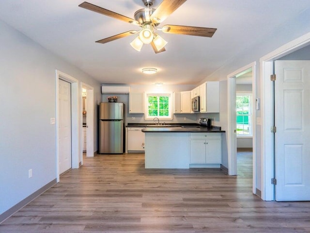 37 Bog Rd, Augusta, ME 04330 - kitchen featuring stainless steel appliances, dark countertops, white cabinetry, a peninsula, and a sink