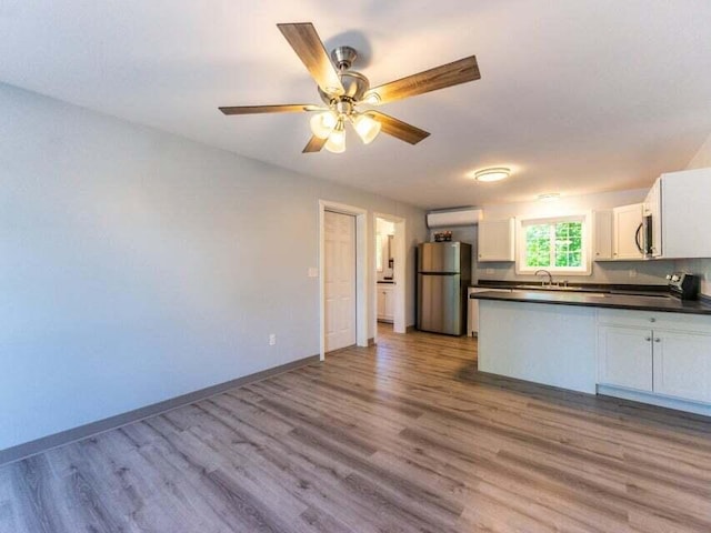 37 Bog Rd, Augusta, ME 04330 - kitchen featuring stainless steel appliances, dark countertops, wood finished floors, white cabinetry, and a peninsula