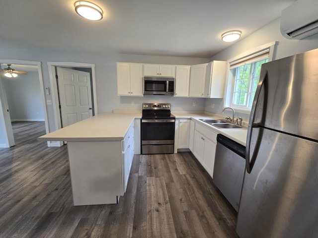 37 Bog Rd, Augusta, ME 04330 - kitchen with appliances with stainless steel finishes, a sink, a wall mounted AC, a peninsula, and dark wood-style flooring