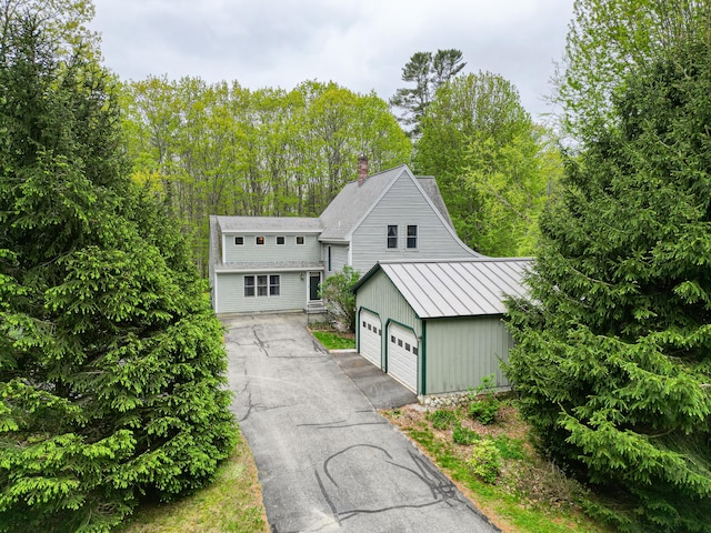 17 Lincoln Ln, Newcastle, ME 04553 - view of front of home featuring a chimney, a standing seam roof, an outbuilding, and metal roof