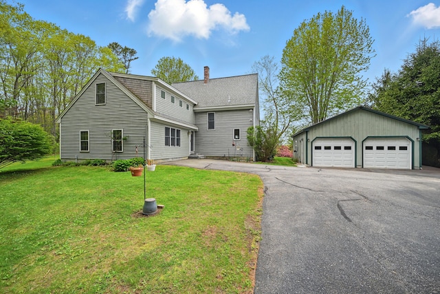 17 Lincoln Ln, Newcastle, ME 04553 - view of front facade with an outbuilding, a garage, a chimney, and a front yard