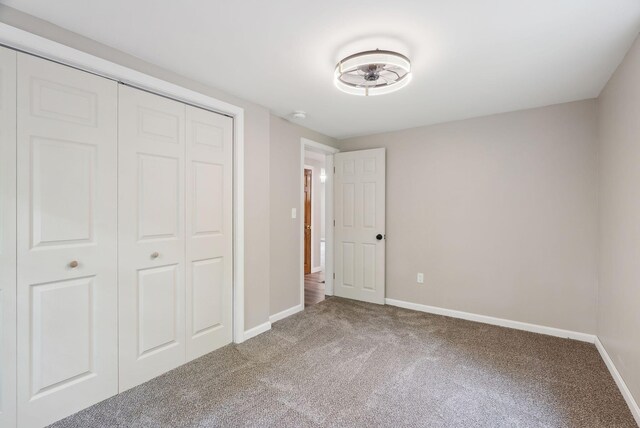 834-836 Sebago Rd, Sebago, ME 04029 - unfurnished bedroom featuring carpet, baseboards, and a closet