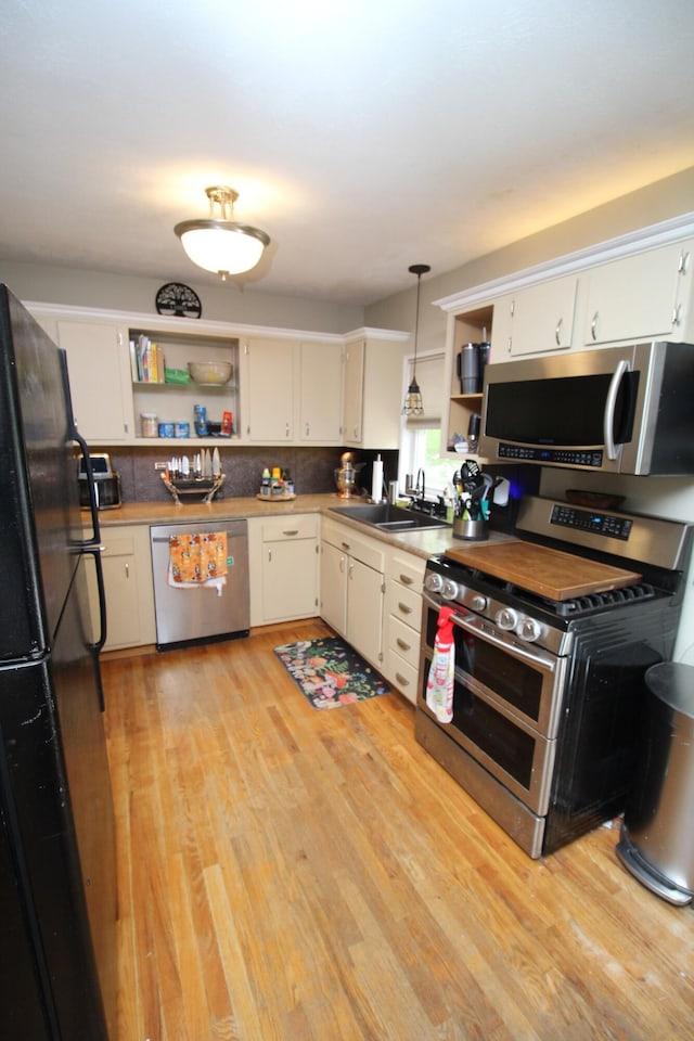 24 Mitchell St, Lewiston, ME 04240 - kitchen with appliances with stainless steel finishes, open shelves, a sink, and light wood-type flooring