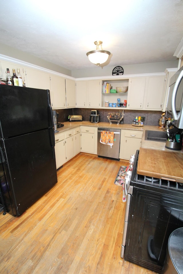24 Mitchell St, Lewiston, ME 04240 - kitchen with appliances with stainless steel finishes, light wood-type flooring, open shelves, and light countertops
