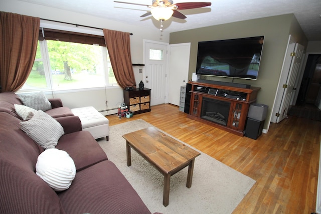 24 Mitchell St, Lewiston, ME 04240 - living room with wood finished floors, ceiling fan, healthy amount of natural light, and a baseboard radiator