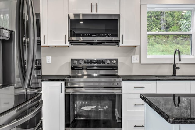61 Main Rd, Eddington, ME 04428 - kitchen featuring appliances with stainless steel finishes, a sink, white cabinets, and dark stone countertops