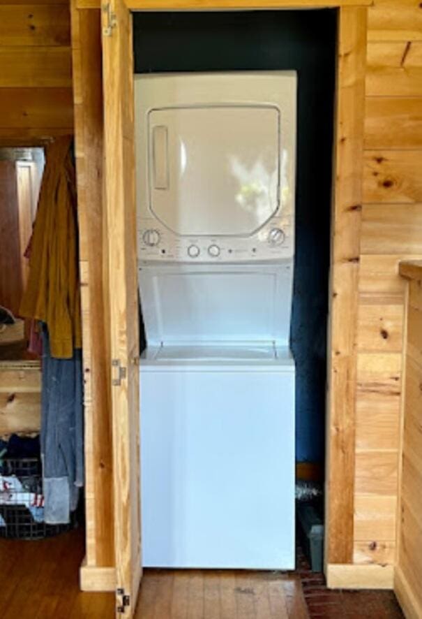 634 N Rd, Mount Chase, ME 04765 - laundry room with stacked washer and clothes dryer, wood finished floors, and wood walls