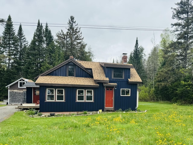 634 N Rd, Mount Chase, ME 04765 - view of front of house featuring roof with shingles, a chimney, board and batten siding, and a front yard