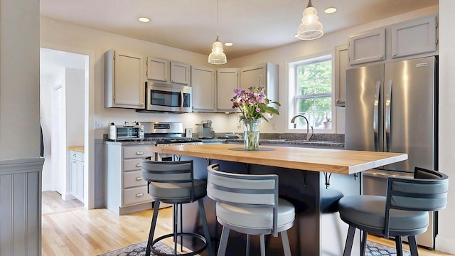 53 Gray Rd, Gorham, ME 04038 - kitchen featuring butcher block countertops, stainless steel appliances, a sink, a breakfast bar, and recessed lighting