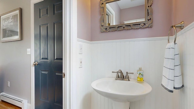 53 Gray Rd, Gorham, ME 04038 - bathroom with a baseboard heating unit, a wainscoted wall, and a sink