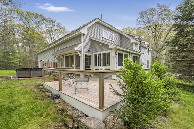 241 Old Stage Rd, Arrowsic, ME 04530 - back of house with a hot tub, a deck, a lawn, and a sunroom