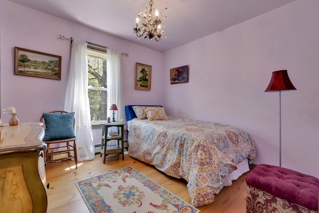 241 Old Stage Rd, Arrowsic, ME 04530 - bedroom with wood finished floors and a chandelier
