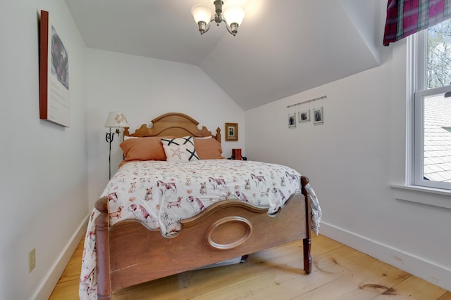241 Old Stage Rd, Arrowsic, ME 04530 - bedroom with multiple windows, a chandelier, light wood-type flooring, vaulted ceiling, and baseboards