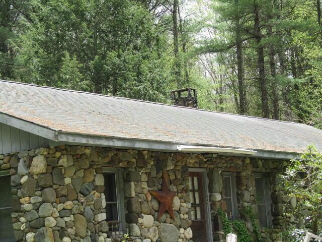 33 Log N Rock Rd, Eliot, ME 03442 - exterior view of stone siding, a shingled roof, and a forest