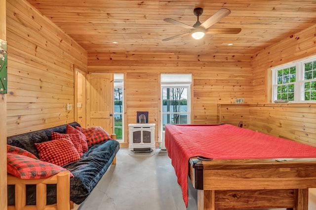 700 Pond Rd, Saint Albans, ME 04971 - bedroom with a wood stove, concrete flooring, access to exterior, wooden walls, and wood ceiling