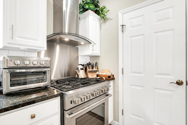 19 Winding Brook Ln S Unit 19, Wells, ME 04090 - kitchen featuring wall chimney range hood, gas range, white cabinets, tasteful backsplash, and dark stone counters
