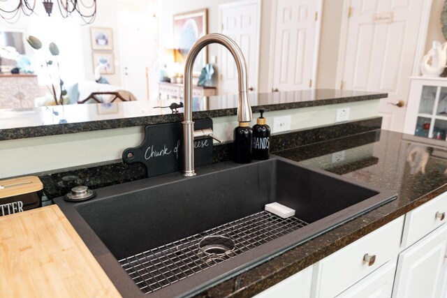 19 Winding Brook Ln S Unit 19, Wells, ME 04090 - kitchen view of a sink, white cabinetry, and dark stone countertops
