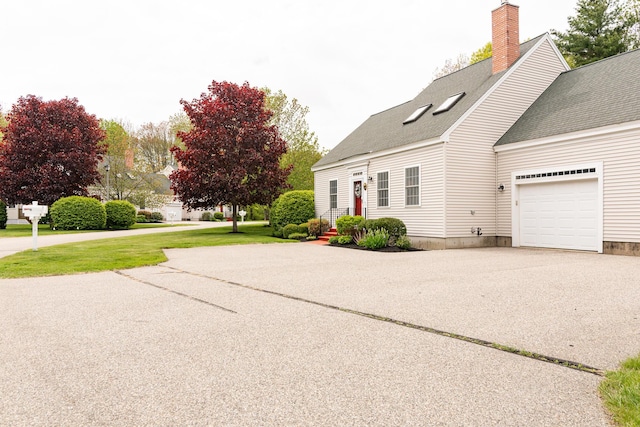 19 Winding Brook Ln S Unit 19, Wells, ME 04090 - view of property exterior featuring roof with shingles, a chimney, a garage, asphalt driveway, and a lawn