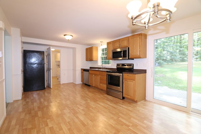 107 Tidy Rd Unit A & B, Eliot, ME 03903 - kitchen featuring appliances with stainless steel finishes, dark countertops, light wood-style floors, a chandelier, and healthy amount of natural light