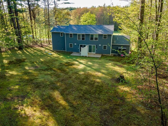 107 Tidy Rd Unit A & B, Eliot, ME 03903 - back of property featuring a yard, a forest view, a shingled roof, and a patio