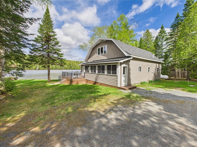 1107 S Shore Rd, Madawaska Lake Twp, ME 04783 - view of front of house with a deck with water view and a front lawn