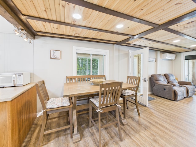 1107 S Shore Rd, Madawaska Lake Twp, ME 04783 - dining area featuring a wall mounted AC, light wood-style floors, beamed ceiling, recessed lighting, and baseboards