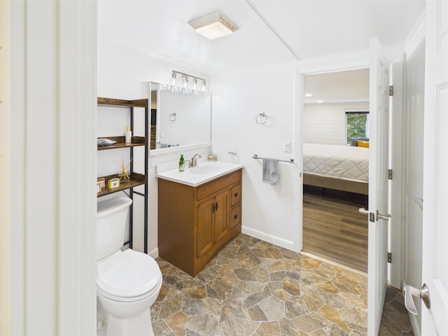 1107 S Shore Rd, Madawaska Lake Twp, ME 04783 - ensuite bathroom with vanity, toilet, stone finish flooring, and baseboards