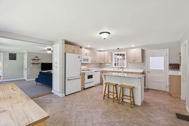 83 E Cote St, Lewiston, ME 04240 - kitchen with white appliances, a sink, a kitchen island, recessed lighting, and a kitchen breakfast bar