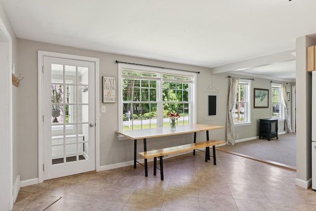 83 E Cote St, Lewiston, ME 04240 - dining area with a wood stove, healthy amount of natural light, baseboards, and light tile patterned floors