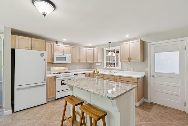 83 E Cote St, Lewiston, ME 04240 - kitchen with white appliances, light brown cabinets, light tile patterned floors, a breakfast bar area, and a center island