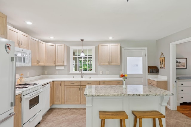 83 E Cote St, Lewiston, ME 04240 - kitchen featuring white appliances, a sink, a kitchen breakfast bar, light tile patterned floors, and light brown cabinets