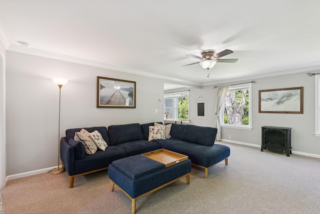 83 E Cote St, Lewiston, ME 04240 - living room with a wood stove, crown molding, a ceiling fan, light carpet, and baseboards