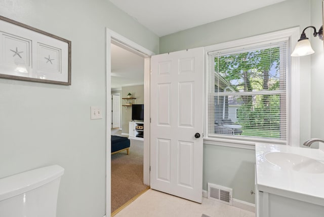 83 E Cote St, Lewiston, ME 04240 - half bath with vanity, toilet, baseboards, and tile patterned flooring
