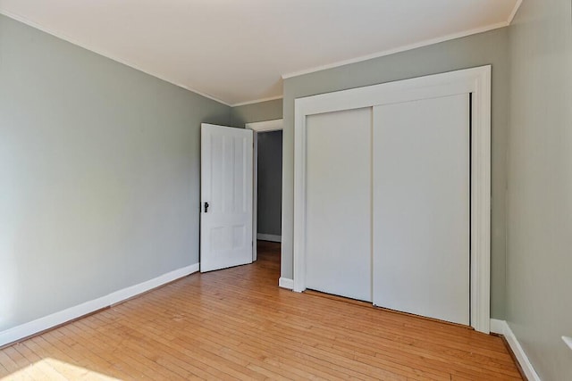 2 Elm Ter, Waterville, ME 04901 - unfurnished bedroom featuring light wood-style floors, baseboards, crown molding, and a closet