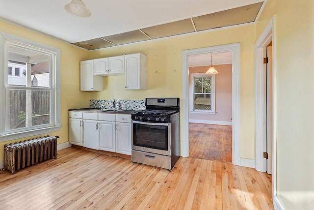 2 Elm Ter, Waterville, ME 04901 - kitchen with radiator heating unit, gas stove, a sink, dark countertops, and light wood-type flooring