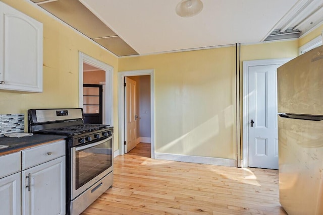 2 Elm Ter, Waterville, ME 04901 - kitchen with stainless steel appliances, dark countertops, light wood finished floors, white cabinets, and baseboards