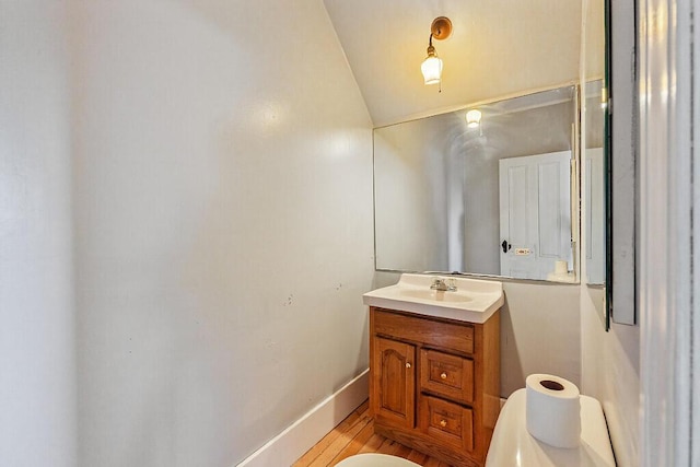 2 Elm Ter, Waterville, ME 04901 - half bathroom with vanity, vaulted ceiling, and toilet
