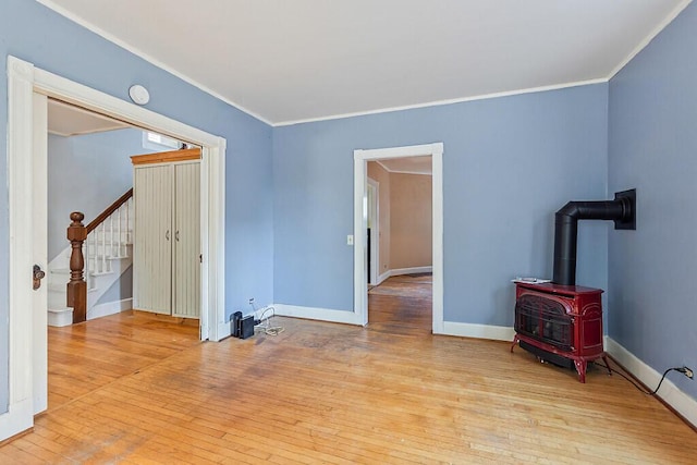 2 Elm Ter, Waterville, ME 04901 - unfurnished room featuring hardwood / wood-style floors, stairs, ornamental molding, a wood stove, and baseboards