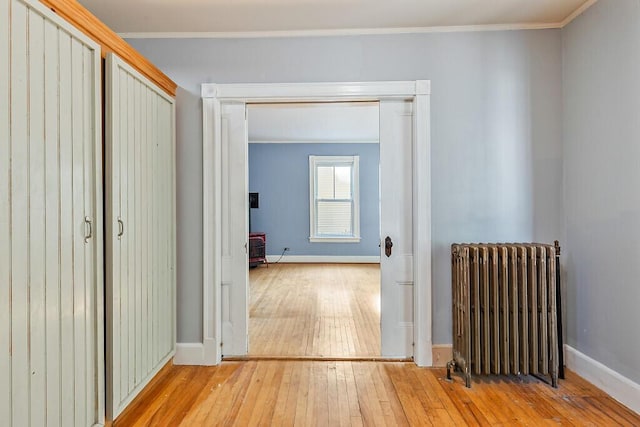 2 Elm Ter, Waterville, ME 04901 - hallway featuring radiator heating unit, wood-type flooring, baseboards, and ornamental molding