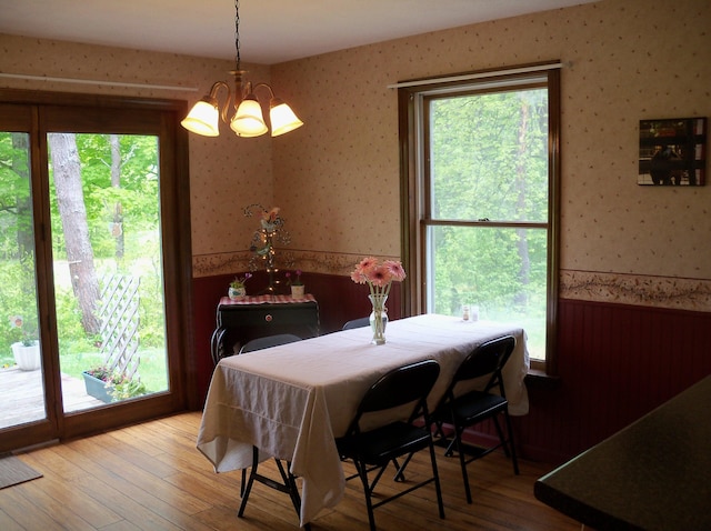 593 S Strong Rd, Strong, ME 04983 - dining room with wallpapered walls, a wainscoted wall, a chandelier, plenty of natural light, and wood finished floors