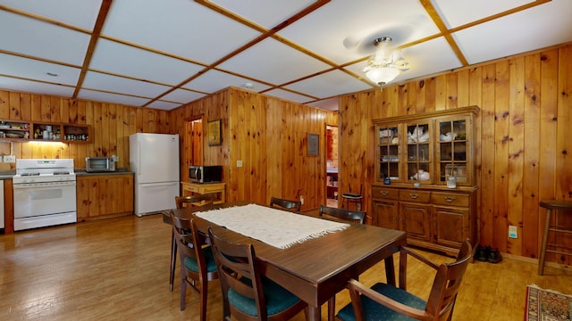 574 Scribner Hill Rd, Otisfield, ME 04270 - dining room with wooden walls, light wood-style flooring, and ceiling fan