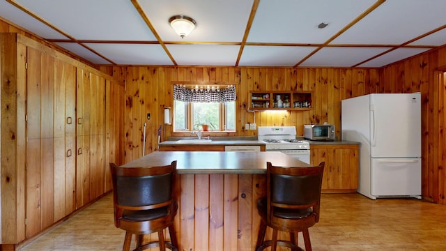 574 Scribner Hill Rd, Otisfield, ME 04270 - kitchen featuring white appliances, wooden walls, a sink, a kitchen bar, and light wood finished floors