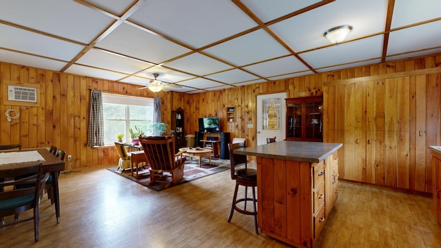 574 Scribner Hill Rd, Otisfield, ME 04270 - kitchen with light wood finished floors, wood walls, ceiling fan, dark countertops, and a kitchen island