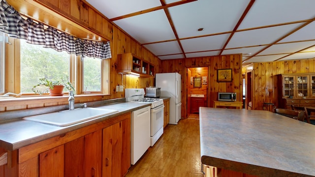574 Scribner Hill Rd, Otisfield, ME 04270 - kitchen featuring white appliances, a sink, wooden walls, light wood-style floors, and brown cabinets
