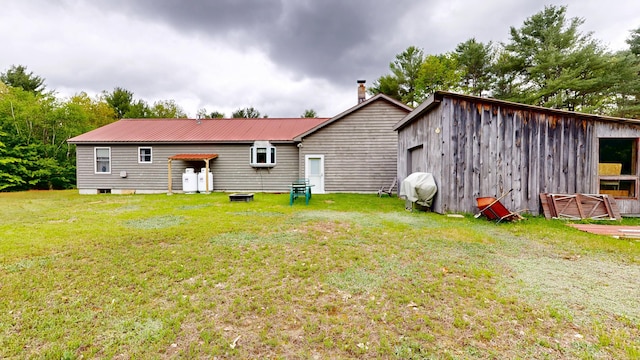 574 Scribner Hill Rd, Otisfield, ME 04270 - back of property with a yard, metal roof, and an outbuilding