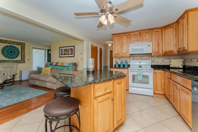 5 Nash Pkwy, Somersworth, NH 03878 - kitchen featuring white appliances, open floor plan, light tile patterned flooring, a kitchen bar, and tasteful backsplash