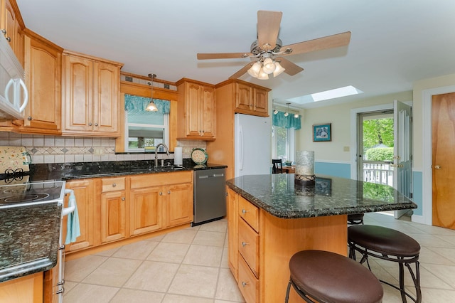 5 Nash Pkwy, Somersworth, NH 03878 - kitchen with white appliances, a sink, a skylight, tasteful backsplash, and light tile patterned floors
