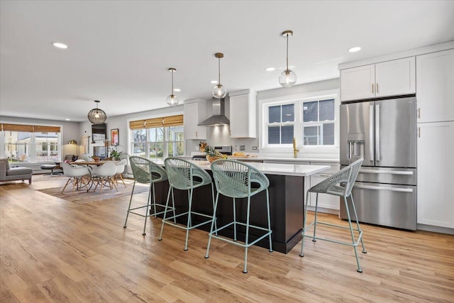 4 Frontrunner Way, Scarborough, ME 04074 - kitchen with stainless steel refrigerator with ice dispenser, wall chimney exhaust hood, a kitchen island, recessed lighting, and light countertops