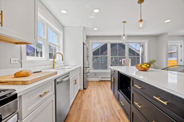 4 Frontrunner Way, Scarborough, ME 04074 - kitchen with stainless steel appliances, a baseboard radiator, light countertops, white cabinets, and pendant lighting